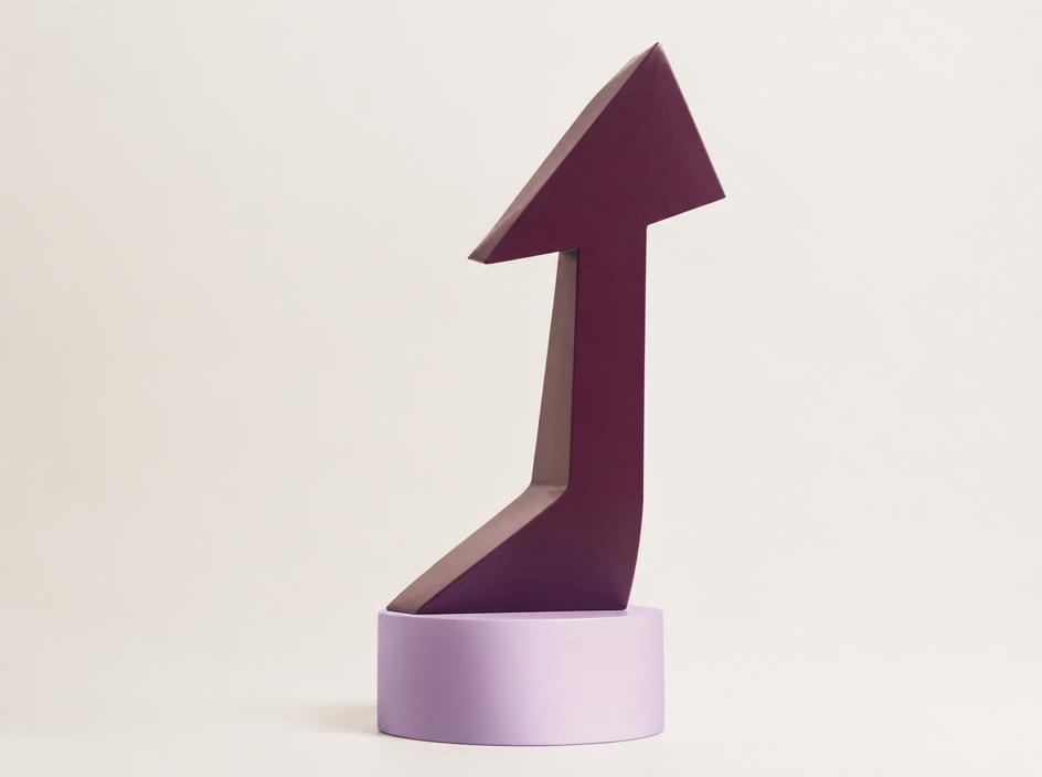 Scultura a forma di freccia viola su base lavanda